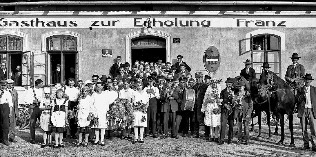 Uczestnicy dożynek z koroną żniwną oraz grupa przebierańców, tzw. słomiana narzeczona, Staniszcze Małe (pow. strzelecki), nie później niż 1931 r., fot. Paul Schau. Klisza szklana, ze zbiorów Muzeum w Gliwicach